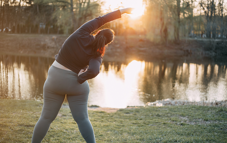 Morning yoga. Young woman doing exercises near the lake,back view. Healthy lifestyle, sport, weight losing, activity concept