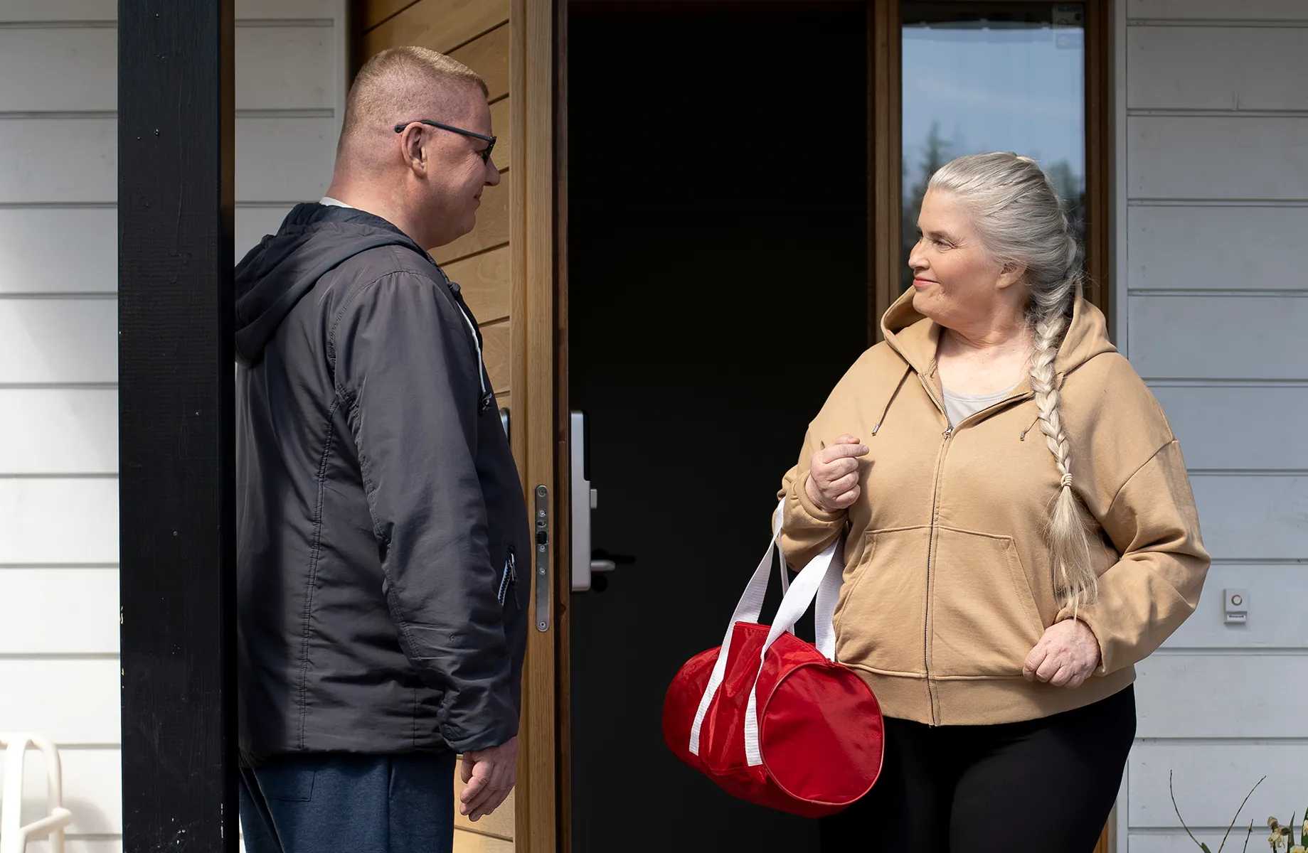 Mies ja nainen ovat ulko-ovella lähdössä liikkumaan