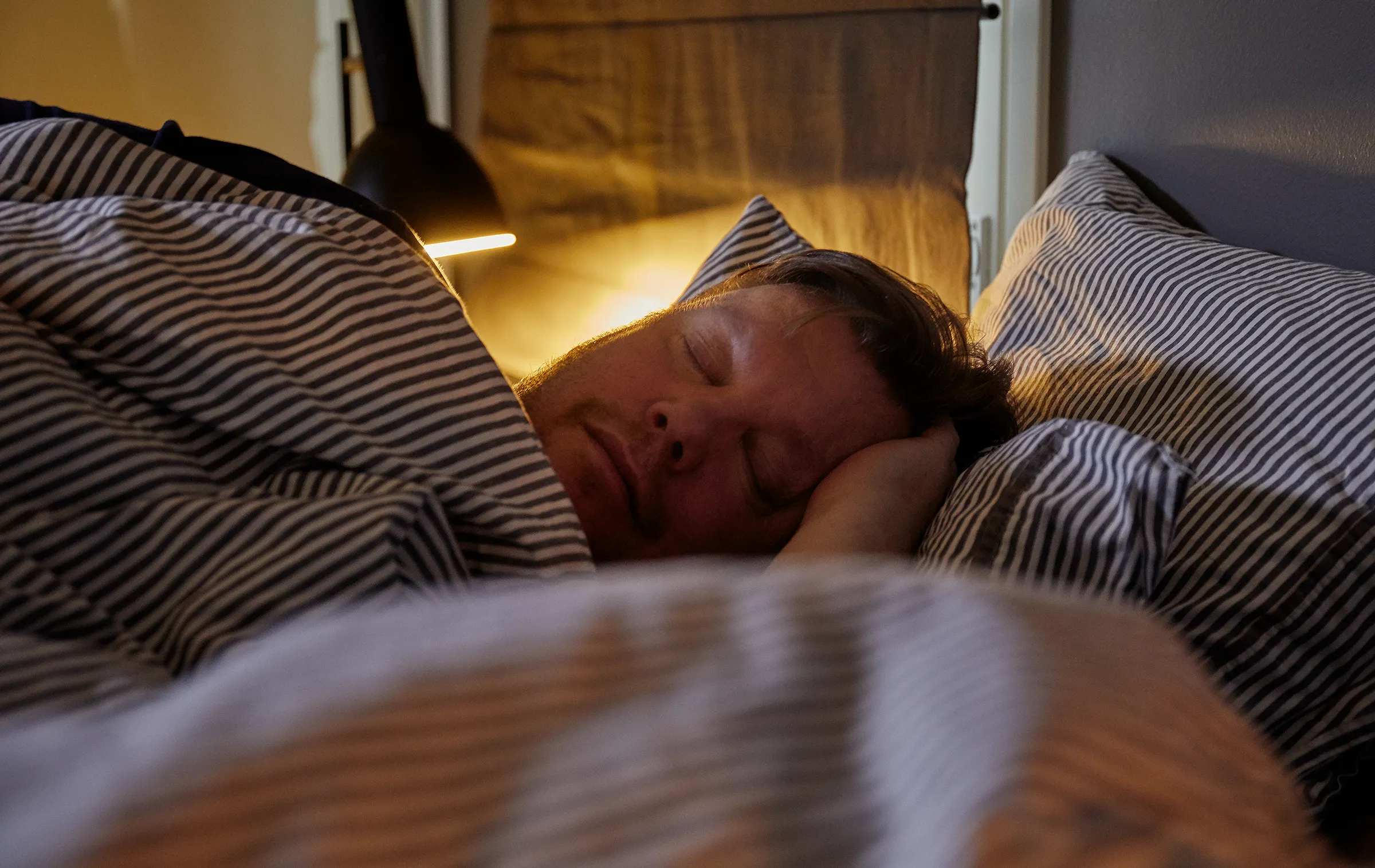 Mies nukkuu levollisesti peiton alla