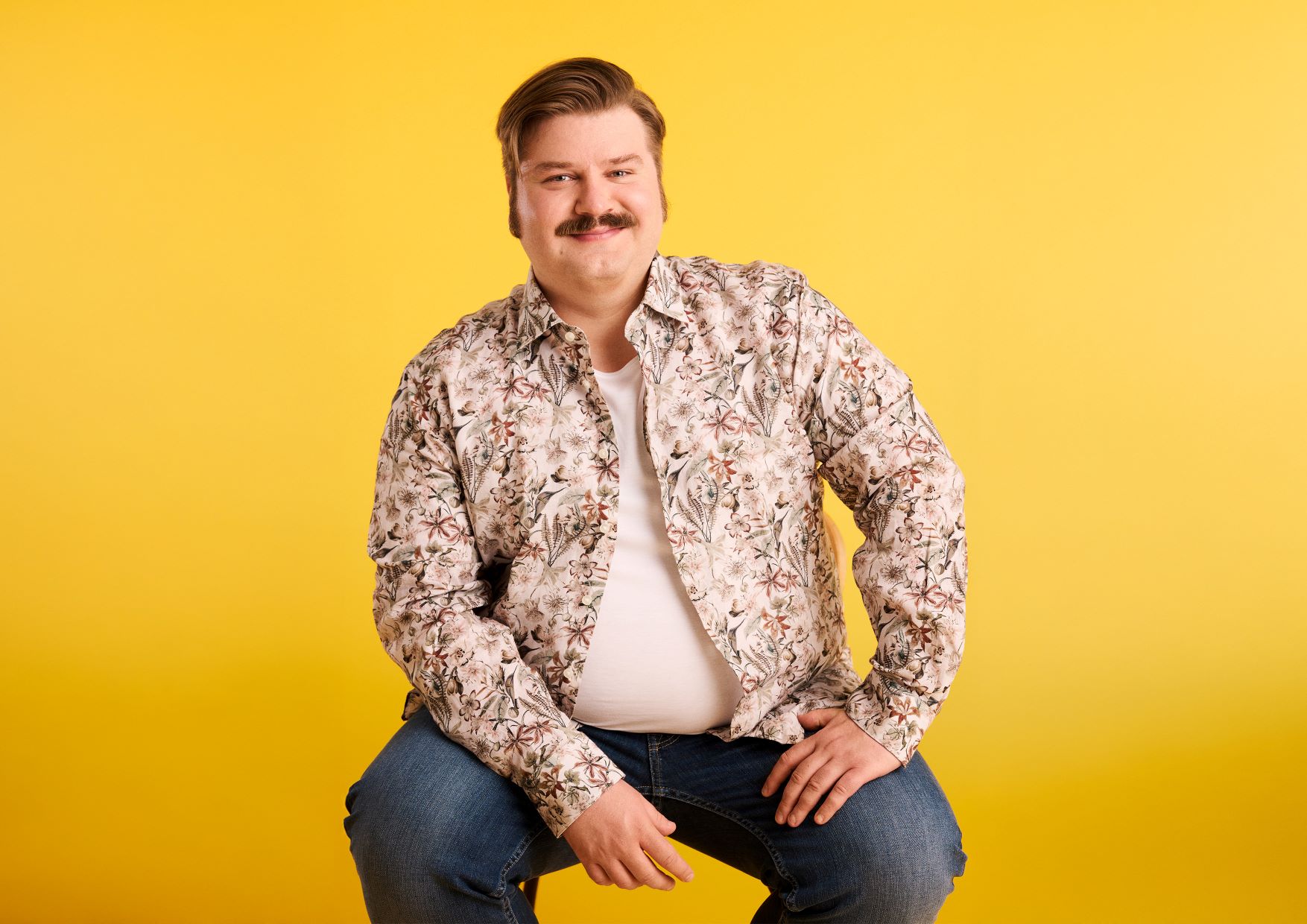 Pari hymyilemässä sohvalla