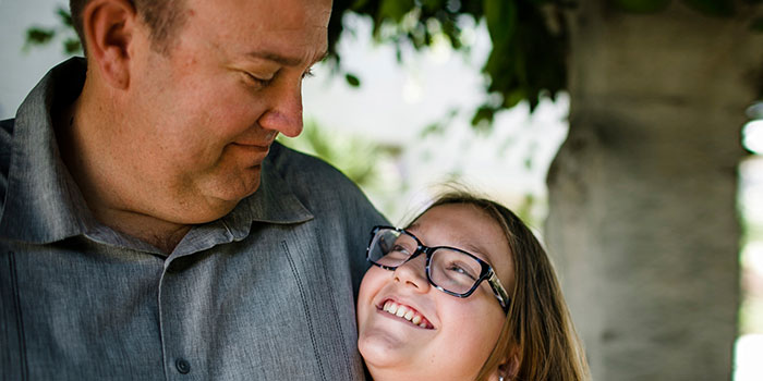 A happy, smiling man sharing a moment with a young girl, illustrating the positive social experiences.
