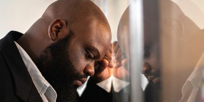 A pensive man reflecting on his health and the challenges of self-reliance in managing obesity.