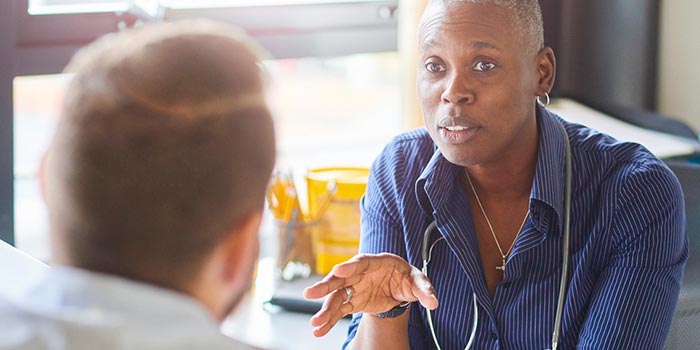 A man in earnest conversation, representing the importance of seeking medical help and challenging the stigmas associated with men's health and obesity.