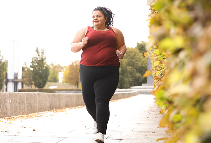Overvektig kvinne jogger