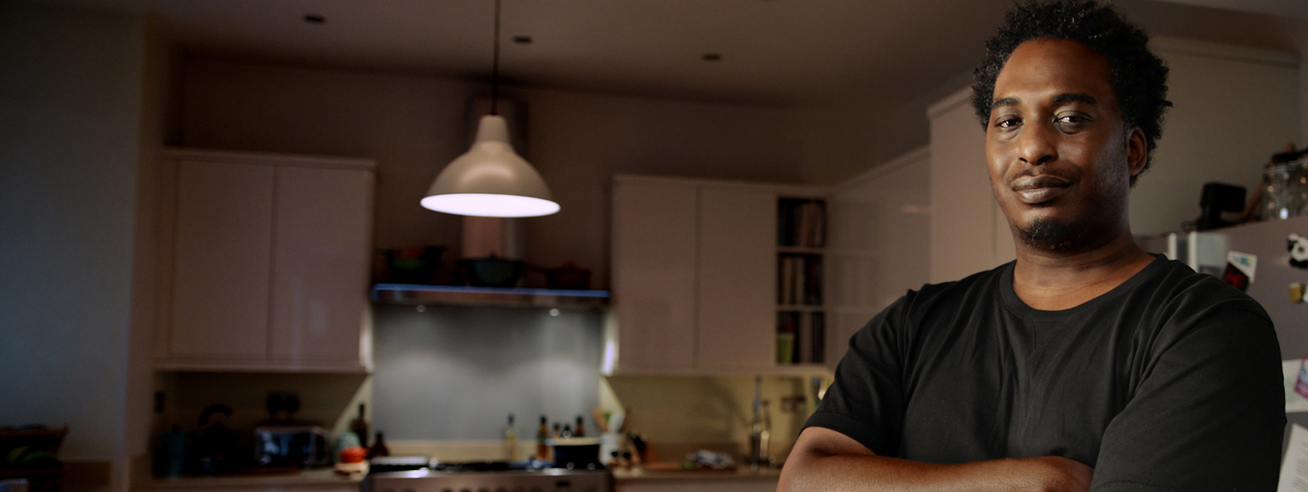 A smiling man standing in his kitchen.