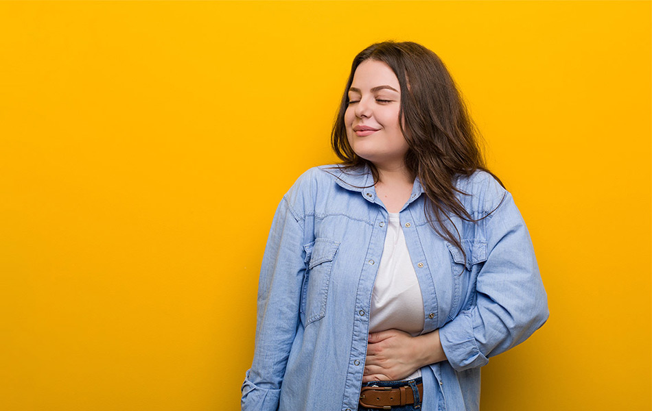 Contented young woman with eyes closed, embodying balanced eating habits and satisfaction