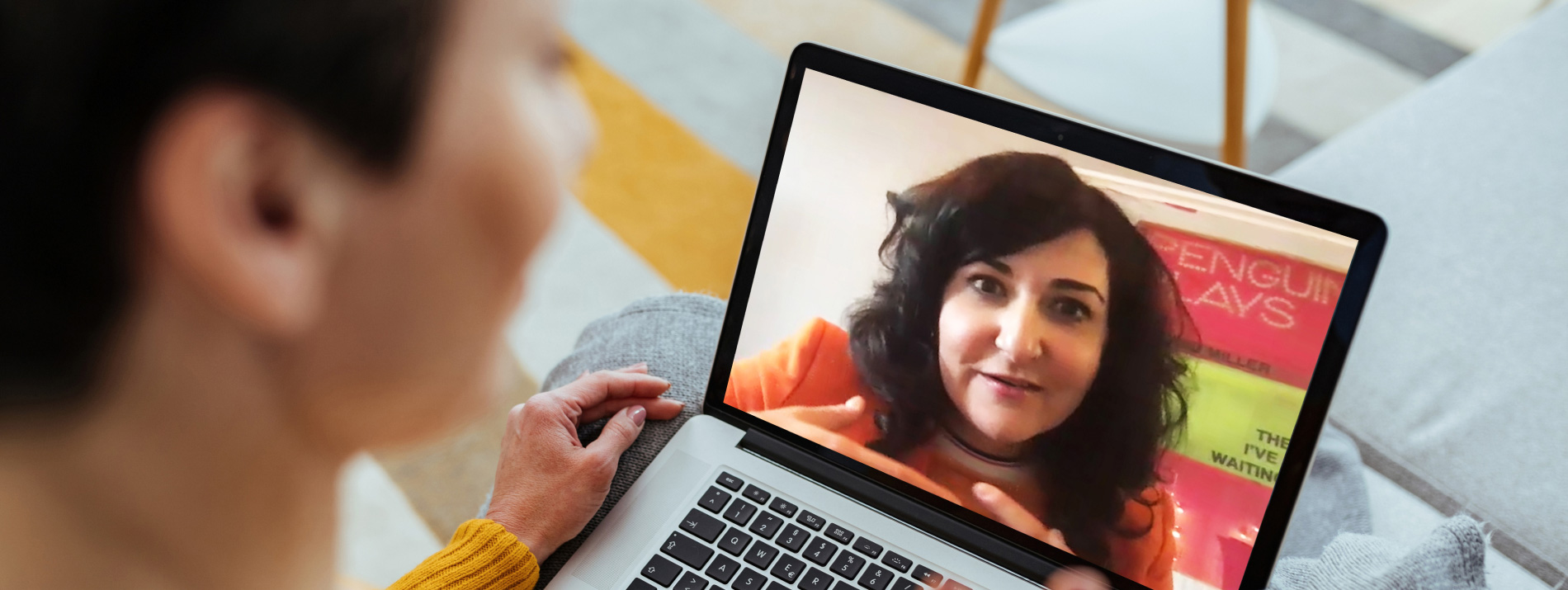 A woman having a videocall with another woman on her laptop.