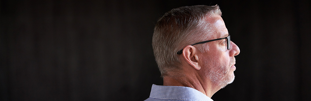 Man wearing glasses looking to the right.