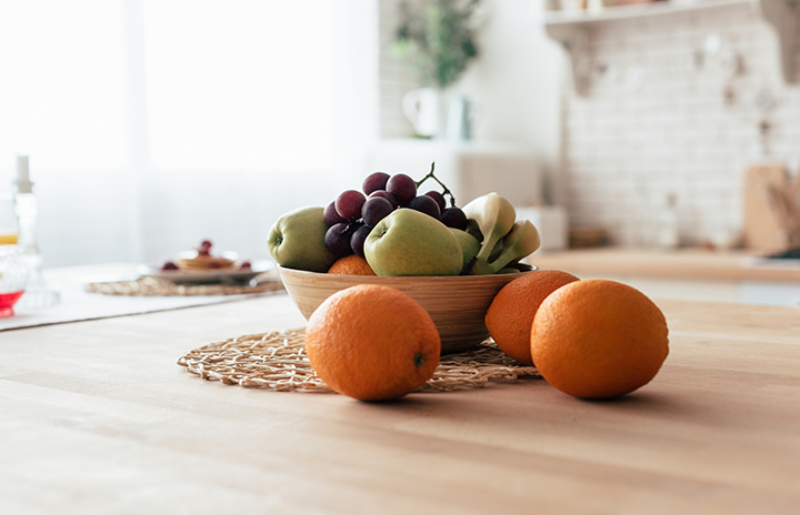 bowl with apples, bananas, grapes and oranges on table